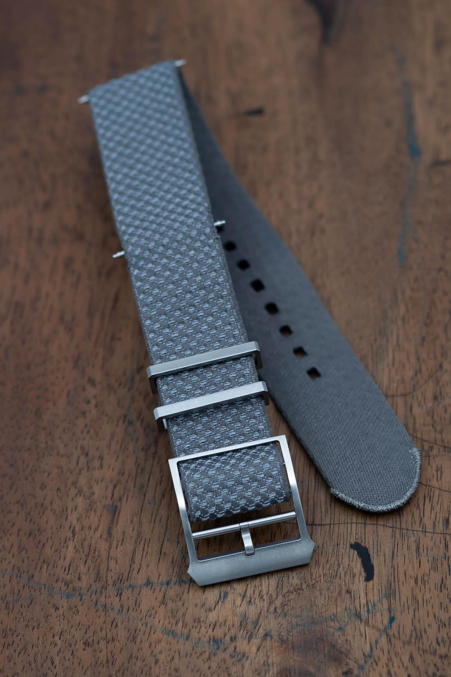 Close-up of the Jacquard weave pattern and 316L stainless steel buckle on a Julien Faure strap